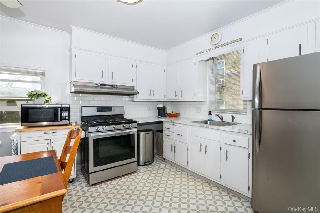 92 Washington Avenue, Unit 1 New Rochelle, NY 10801 - Photo 5 of 22 a kitchen with stainless steel appliances granite countertop a stove a refrigerator a sink a stove and white cabinets