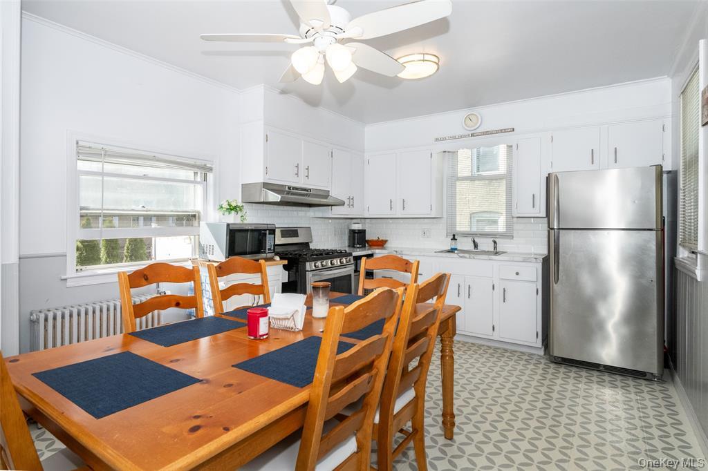 92 Washington Avenue, Unit 1 New Rochelle, NY 10801 - Photo 6 of 22 a kitchen with stainless steel appliances granite countertop a refrigerator a stove a sink dishwasher and a dining table with wooden floor