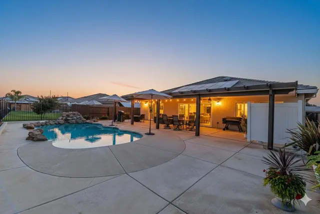 a view of a house with backyard and sitting area