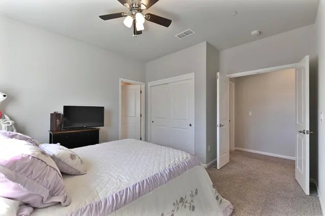 a backyard of a house with table and chairs under an umbrella