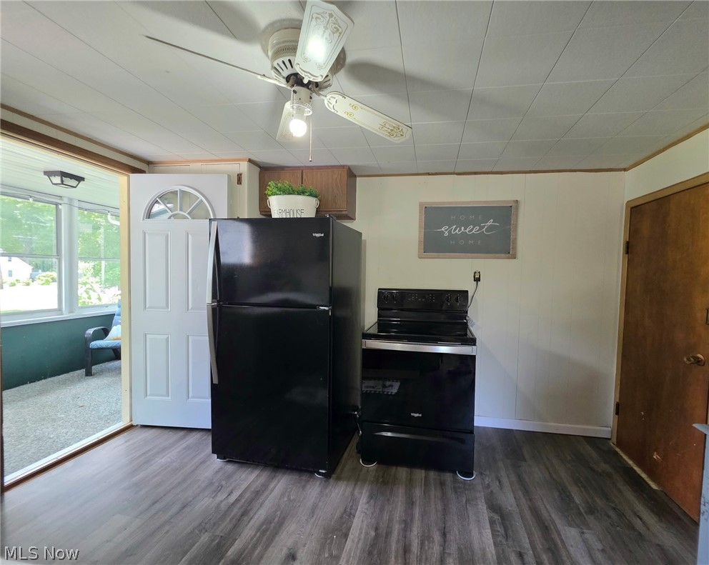2335 West River Road Newton Falls, OH 44444 - Photo 13 of 36 Kitchen area featuring wood-finish flooring, a black refrigerator, a black electric range, and a ceiling fan with light fixture
