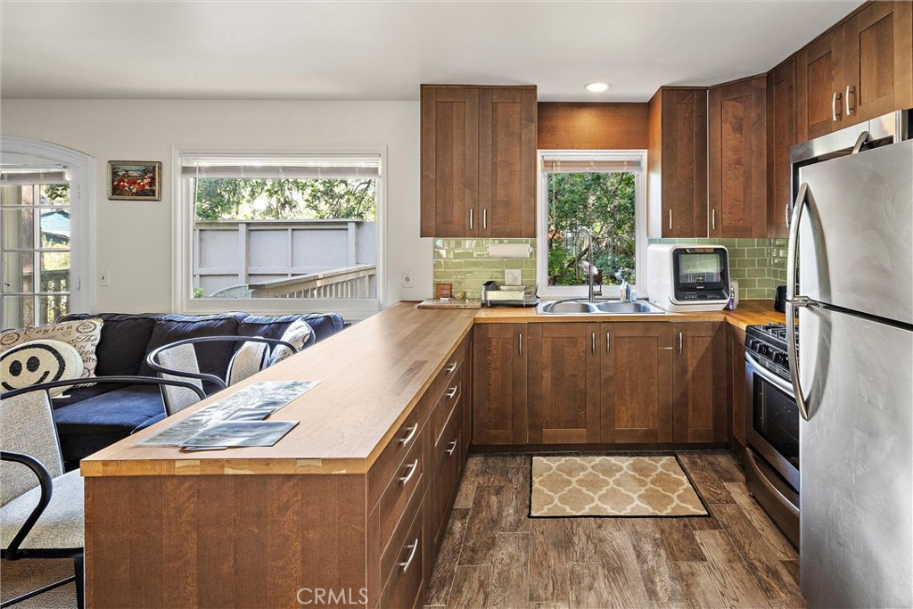 1361 Haddon Drive Cambria, CA 93428 - Photo 11 of 23 a kitchen with sink a refrigerator and wooden cabinets