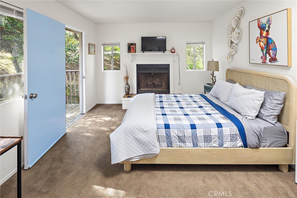 1361 Haddon Drive Cambria, CA 93428 - Photo 15 of 22 a bedroom with a bed and a fireplace