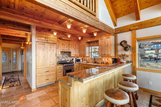 a view of a kitchen with kitchen island granite countertop lots of counter top space and stainless steel appliances