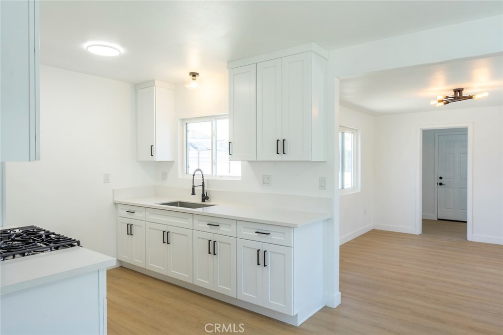 1218 6th Street Redlands, CA 92374 - Photo 4 of 16 a kitchen with white cabinets and a sink