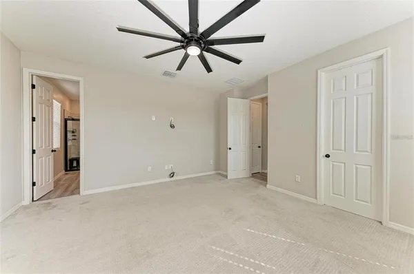a view of an empty room and a ceiling fan