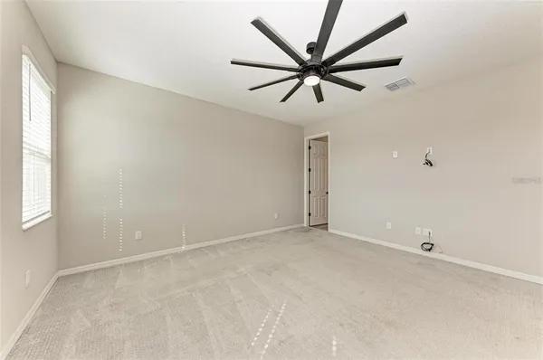 an empty room with a window and a fan