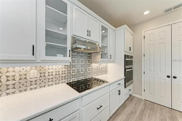 a kitchen with granite countertop white cabinets and white appliances
