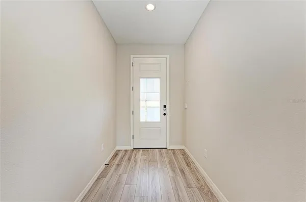 a view of a small space with wooden floor and a window