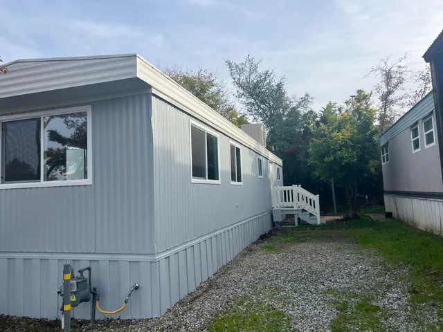 a view of a house with backyard and trees