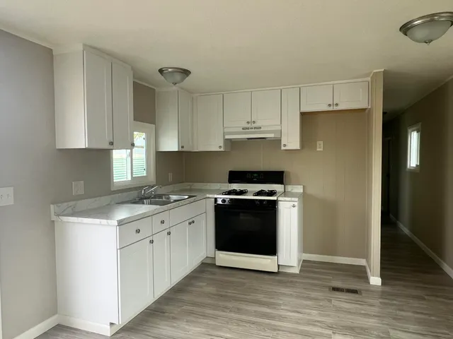 a kitchen with stainless steel appliances a sink stove and refrigerator