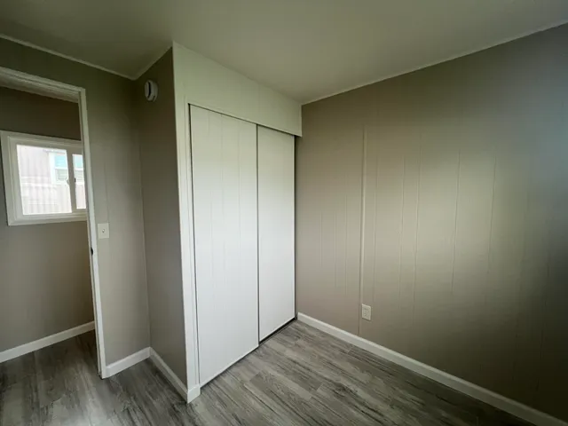 an empty room with wooden floor and closet