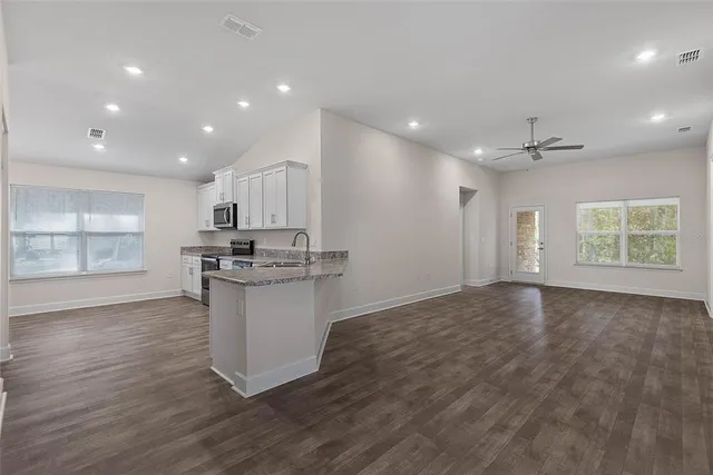 a kitchen with stainless steel appliances granite countertop a sink and dishwasher with wooden floor
