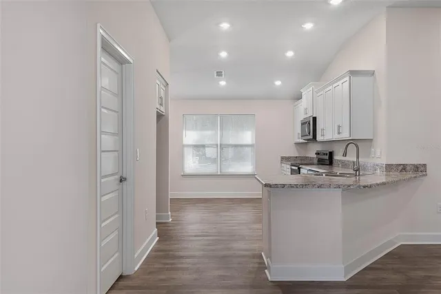 a kitchen with stainless steel appliances granite countertop a sink stove and cabinets