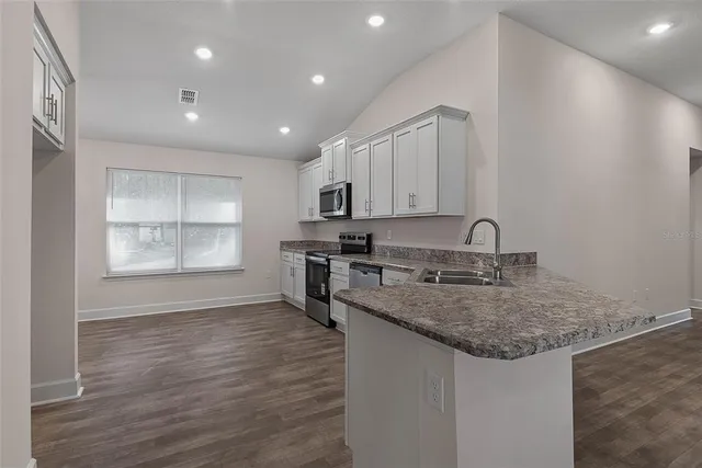 a view of a room with wooden floor ceiling fan and window