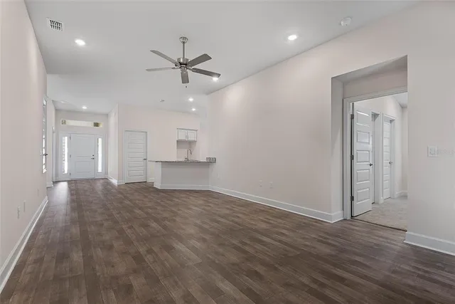 wooden floor in an empty room with a ceiling fan