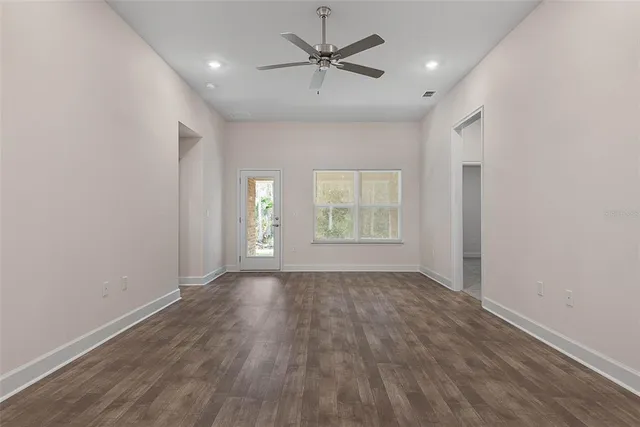 an empty room with closet and a ceiling fan