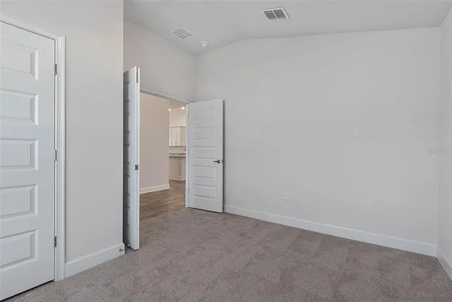 an empty room with closet and wooden door