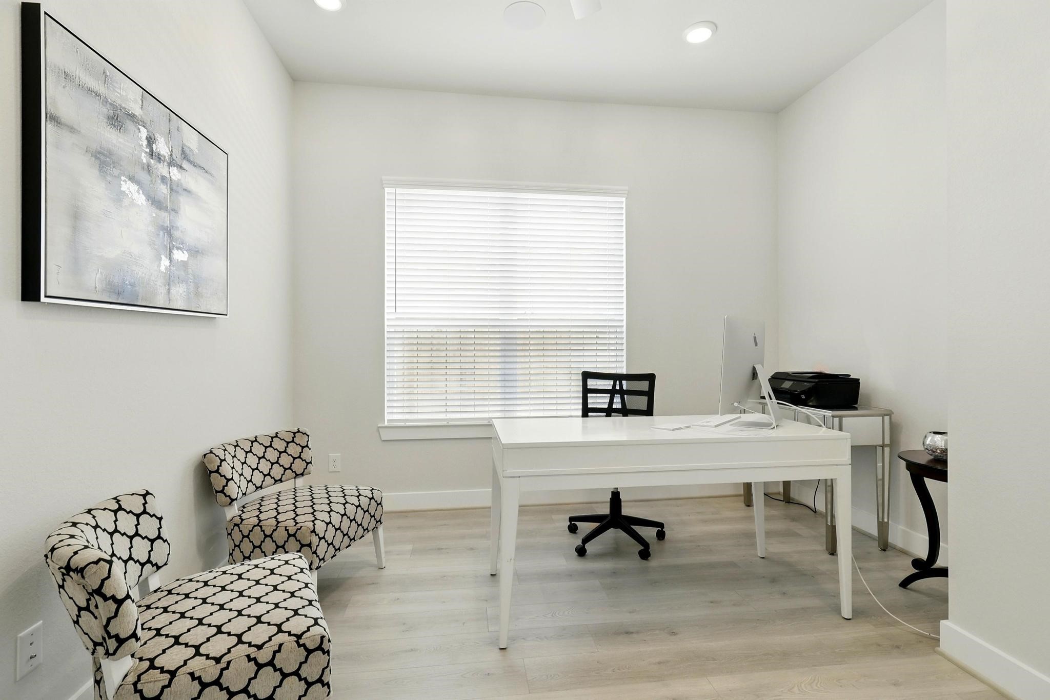 26923 Arethusa Court Spring, TX 77389 - Photo 21 of 44 Spacious modern home office with light wood flooring and neutral walls. It features a large window with blinds, Minimalist decor will complements the clean and organized space.