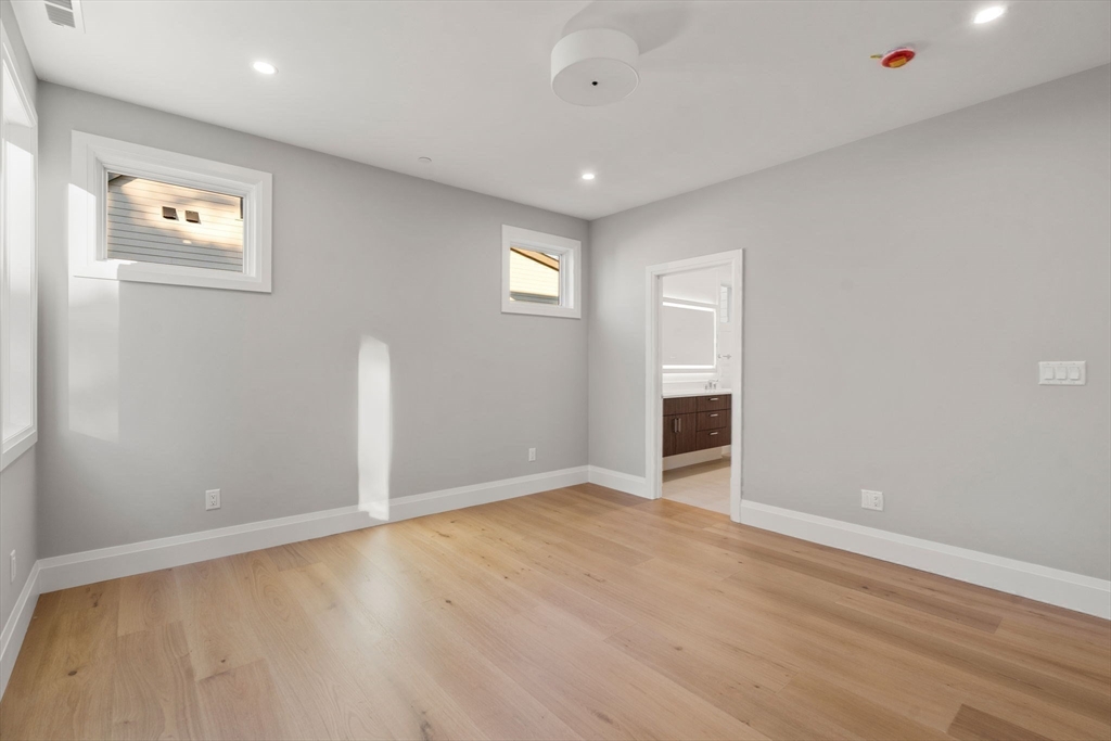 956 Walnut Street, Unit 7 Newton, MA 02459 - Photo 17 of 32 an empty room with wooden floor and windows