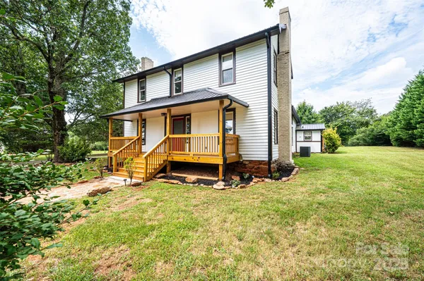 a view of a house with backyard and a tree