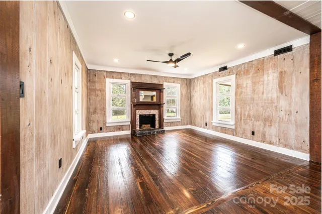 a view of empty room with fireplace and wooden floor