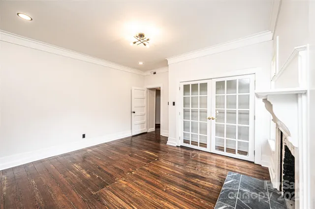 a view of empty room with wooden floor and fireplace