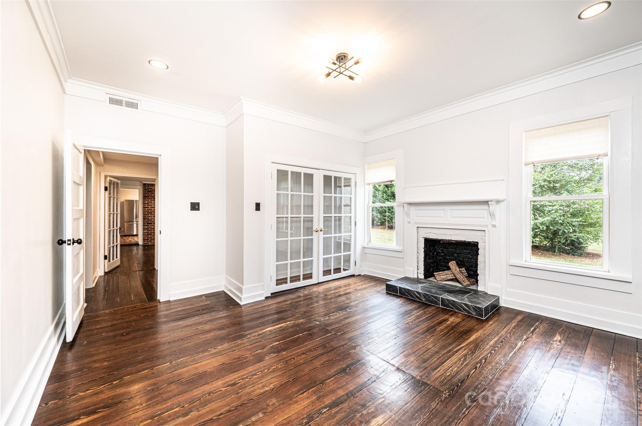 4645 Rifle Range Road Conover, NC 28613 - Photo 20 of 36 a view of a livingroom with wooden floor a fireplace and windows