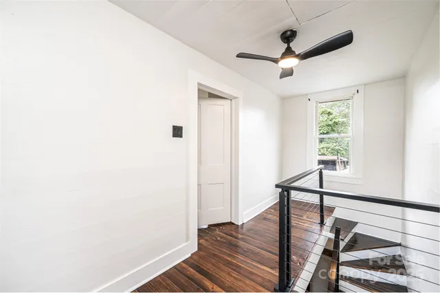 an empty room with wooden floor and entrance