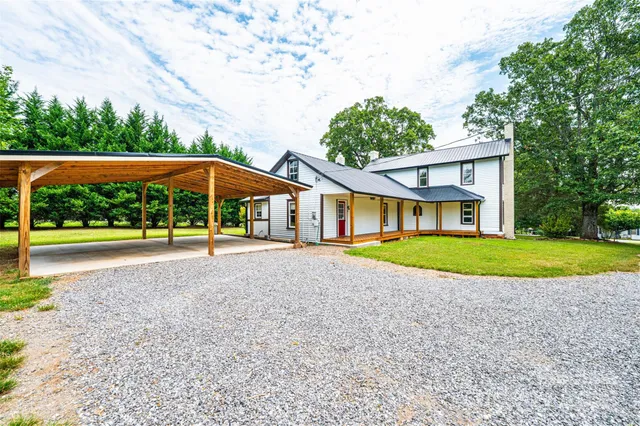 a view of a house with backyard and chairs
