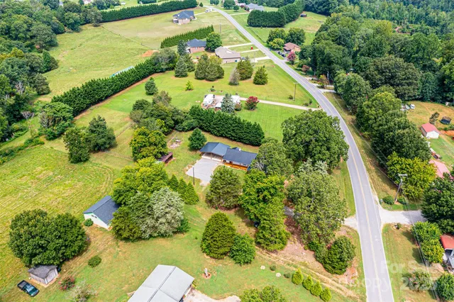 an aerial view of a residential houses with yard