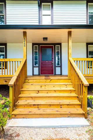 a kitchen with white cabinets white appliances sink and wooden floor