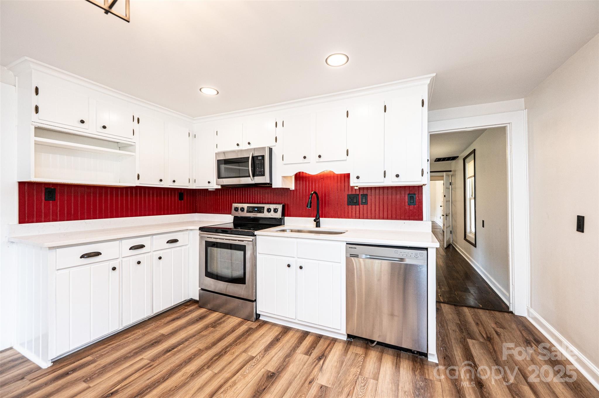 4645 Rifle Range Road Conover, NC 28613 - Photo 8 of 36 a kitchen with white cabinets white appliances sink and wooden floor