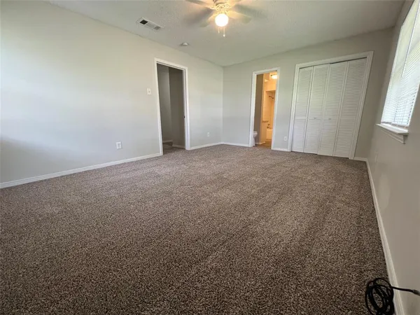 an empty room with windows and closet