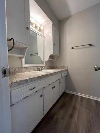 a bathroom with a granite countertop sink and mirror
