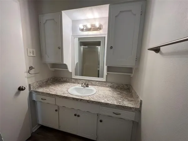 a bathroom with a granite countertop sink and a mirror