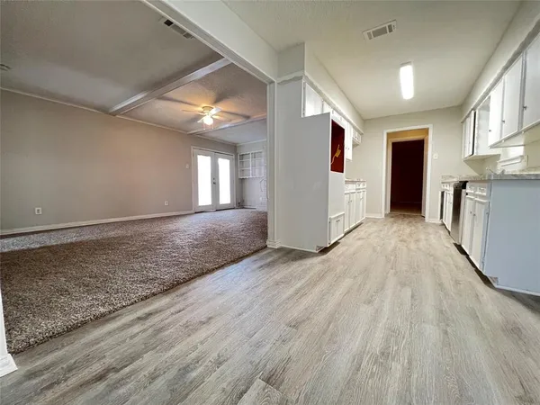 a view of a hallway with wooden floor and staircase