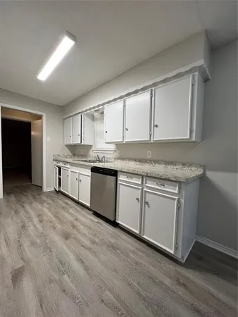 a kitchen with granite countertop white cabinets and white appliances