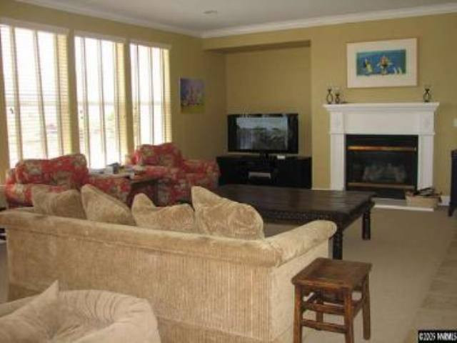 8310 Fairway Ridge Court Reno, NV 89523 - Photo 5 of 9 a living room with furniture a flat screen tv and a fireplace