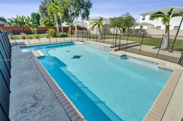 a view of a swimming pool with a patio and a garden