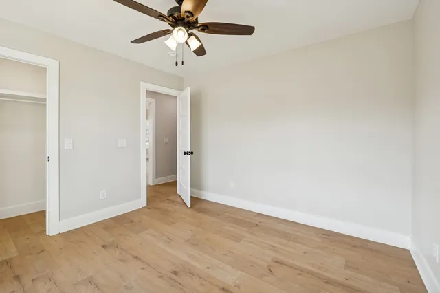 an empty room with a empty space and a ceiling fan