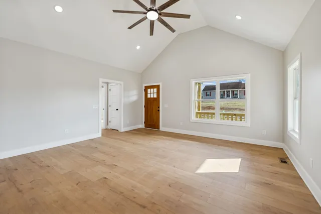 an empty room with fan and windows