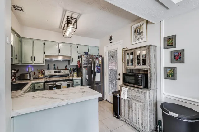 a kitchen with stainless steel appliances a stove refrigerator sink and cabinets