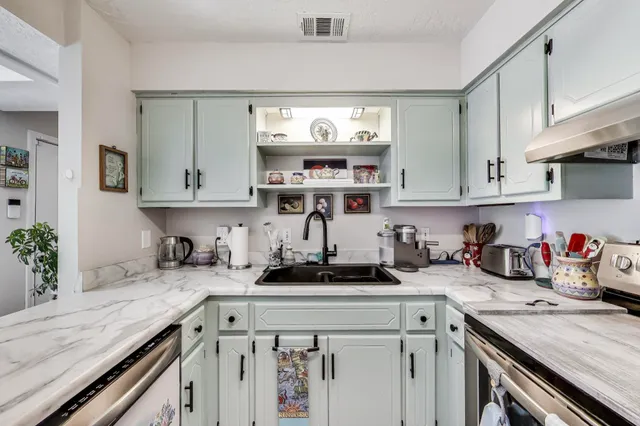 a kitchen with stainless steel appliances granite countertop a sink stove and cabinets