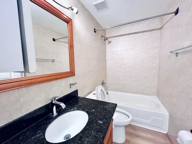 a bathroom with a sink a toilet and a mirror
