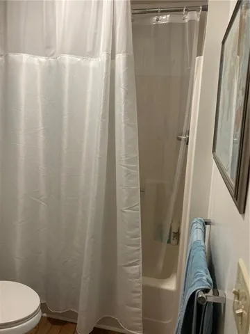 a white toilet sitting next to a shower