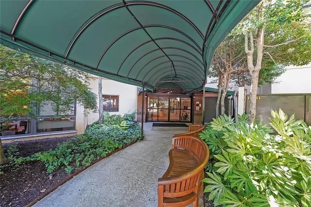 a backyard of a house with table and chairs under an umbrella