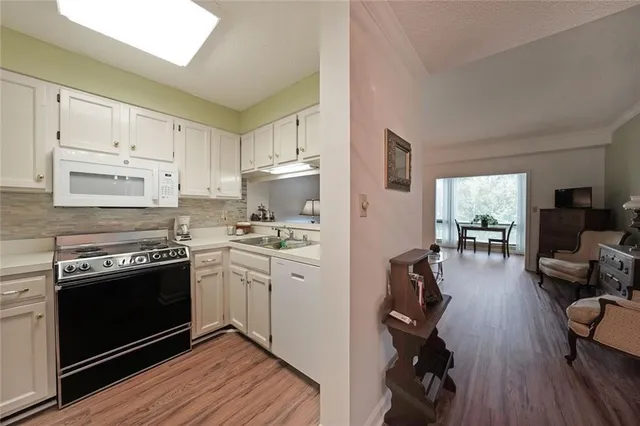 a kitchen with cabinets appliances and wooden floor