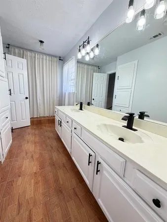 a spacious bathroom with a double vanity sink and a mirror