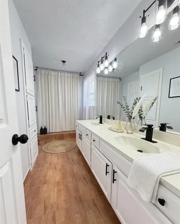 a bathroom with a double vanity sink mirror and shower